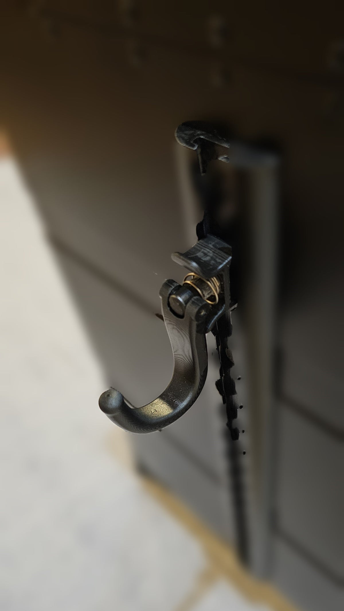 Paradox Aviation black metal cargo track hook accessory mounted on a professional flight crew luggage case