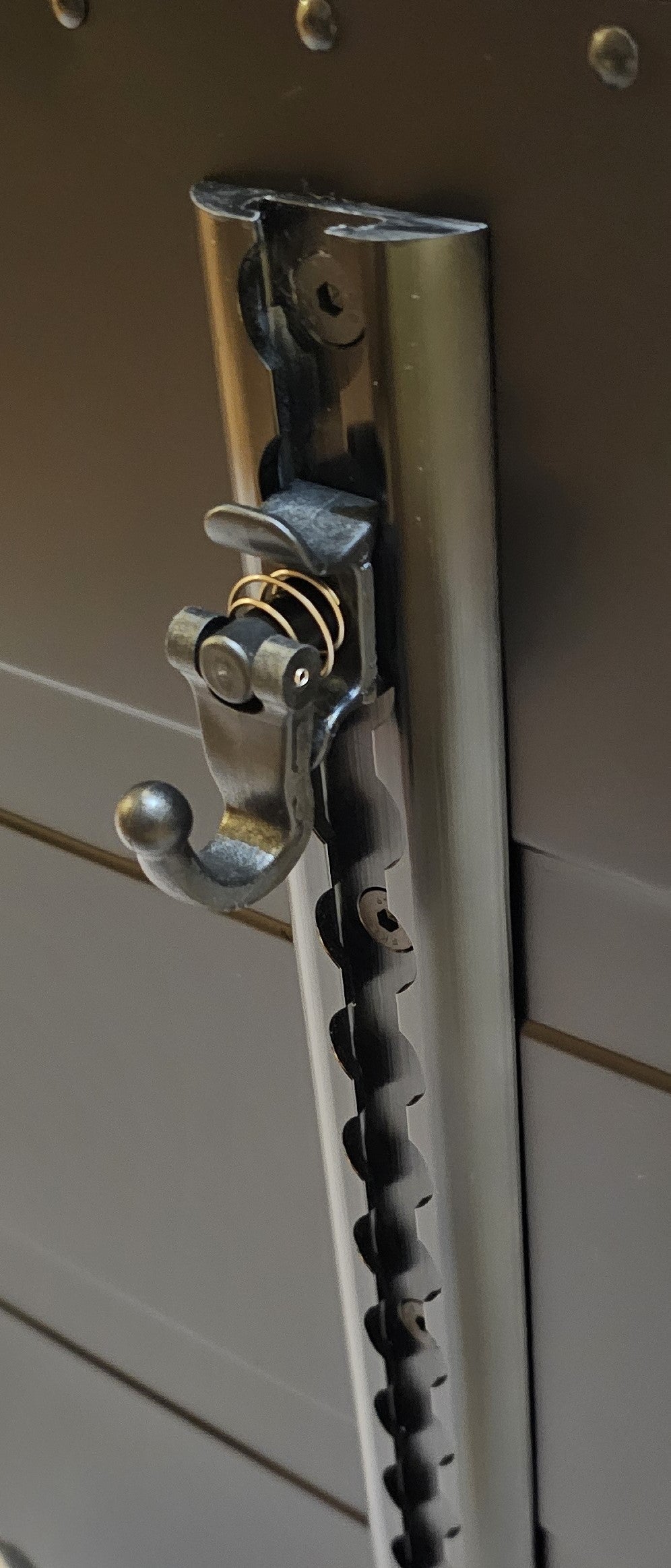 Paradox Aviation cargo track with a black metal spring-loaded hook attached for securing flight crew luggage