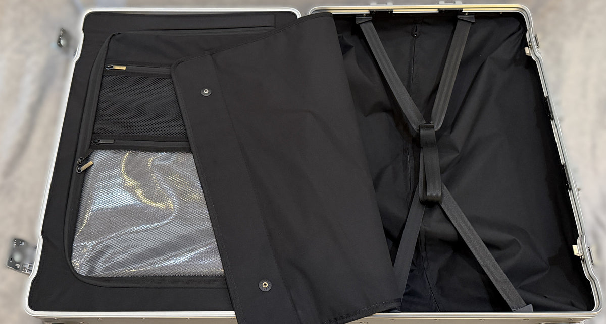 Open interior of a Paradox Aviation 25 inch GEN2 Frequent Flyer luggage case featuring a wet clothes pouch and straps