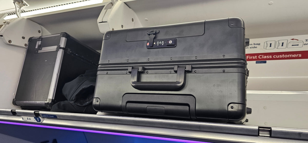 Paradox Aviation 25-inch GEN2 professional flight crew roll aboard luggage in black stored in an airplane overhead bin
