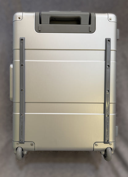 Paradox Aviation 22-inch GEN2 Starlight silver aluminum roll aboard suitcase with matte grey handle and wheels.