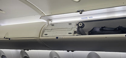 Paradox Aviation 22 inch GEN2 Frequent Flyer silver carry-on luggage stored in a CRJ-200 airplane overhead bin