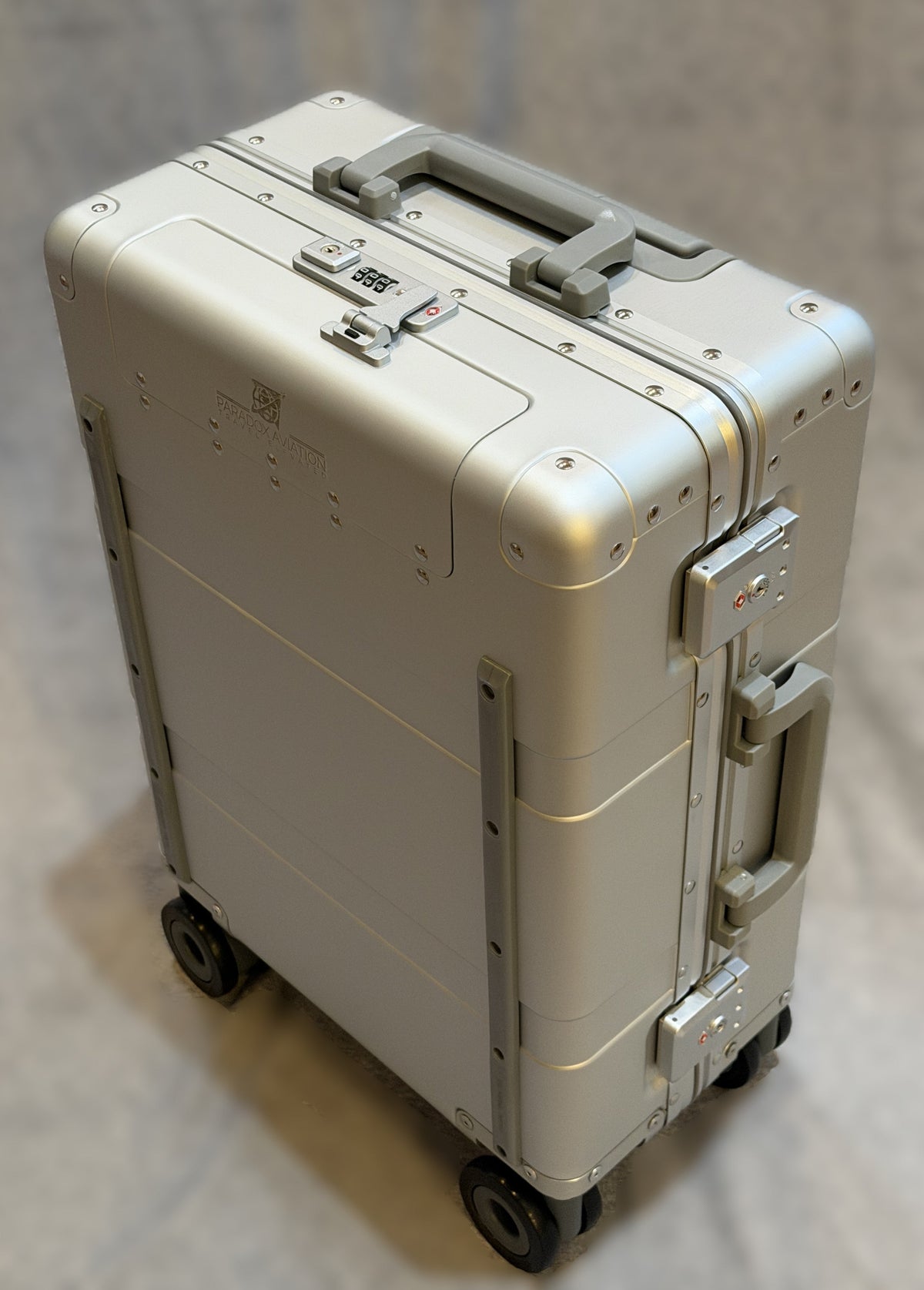 Paradox Aviation Starlight silver GEN2 22-inch hard-shell carry-on luggage with star light matte gray handles and four wheels.