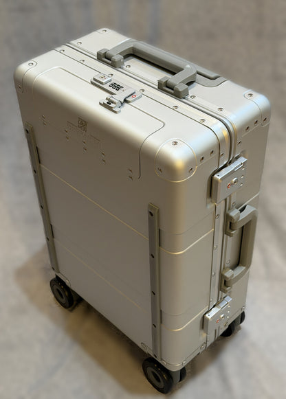 Paradox Aviation Starlight silver GEN2 22-inch hard-shell carry-on luggage with star light matte gray handles and four wheels.