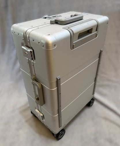 Paradox Aviation 25-inch GEN2 Frequent Flyer hard-shell silver aluminum luggage with matte grey wheels and handle.